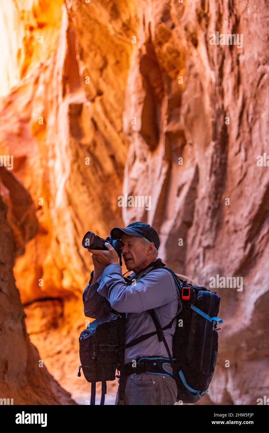 United States, Utah, Escalante, Senior hiker exploring and photographing rock formations in Kodachrome Basin State Park near Escalante Grand Staircase National Monument Stock Photo