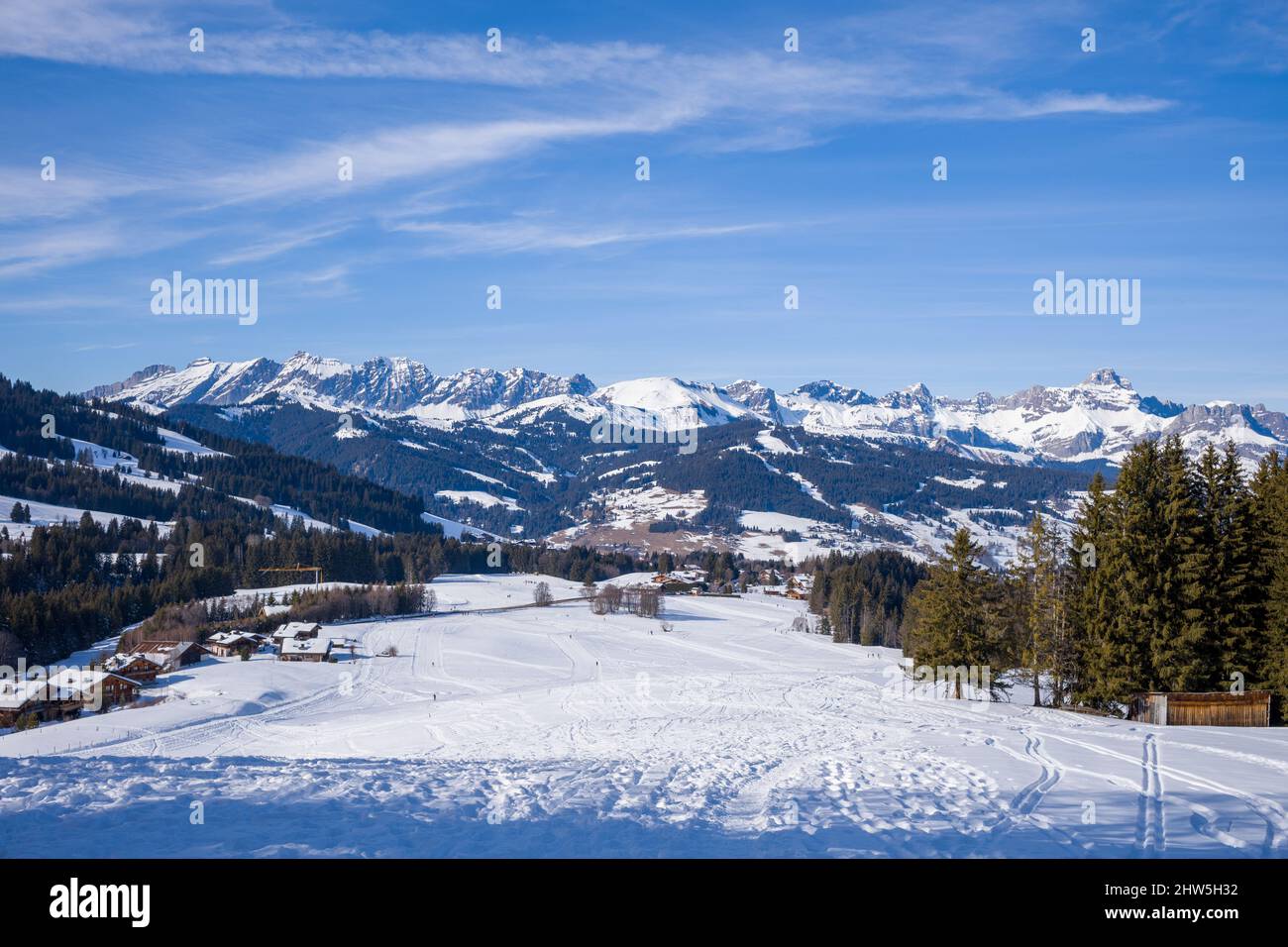 This landscape photo was taken in Europe, in France, Rhone Alpes, in Savoie, in the Alps, in winter. We see La Chaine des Aravis, under the Sun. Stock Photo