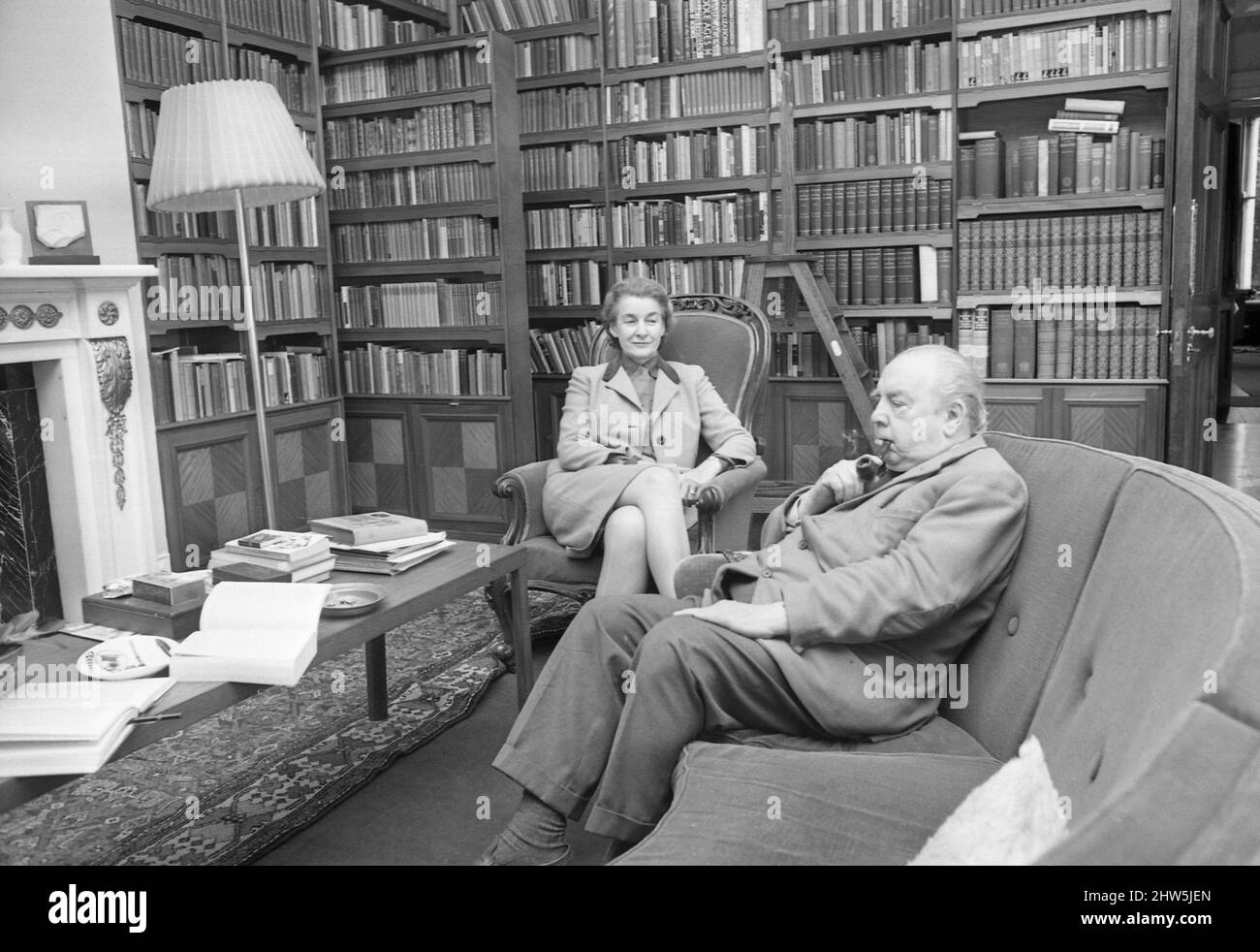 Novelist J. B. Priestley in the library of his home with his wife Jacquetta Hawkes at Kissing Tree House in the village of Alveston near Stratford.21st October 1968 Stock Photo