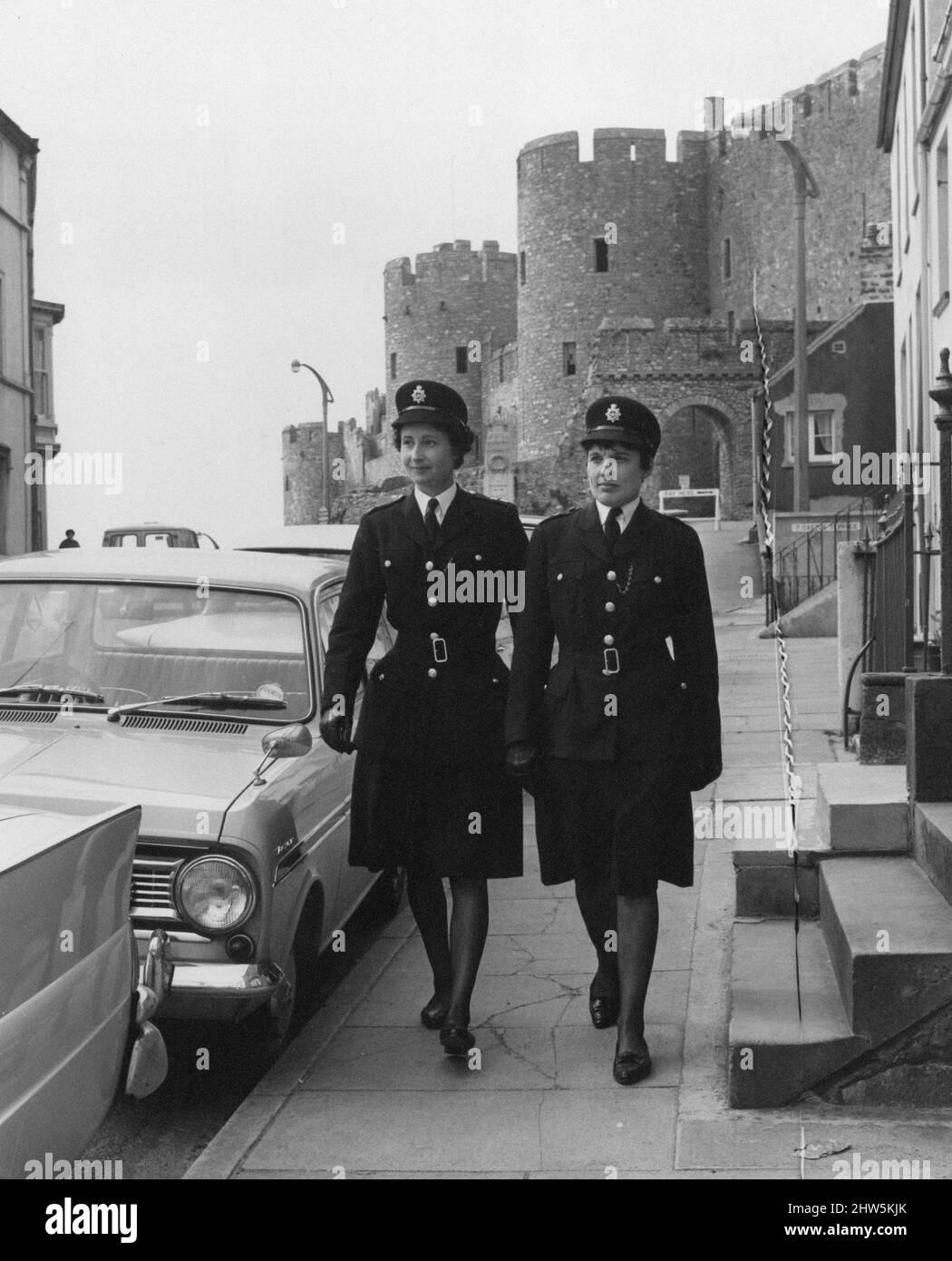 Women Police Officers, Pembrokeshire, West Wales, 18th April 1967.  June Roch (right) aged 31 from Bellevue Terrace, Pembroke Dock, and her friend and next door neighbour Ena Davies aged 35, are the only women special constables in South Pembrokeshire.   Pictured, on patrol with Pembroke Castle in background. Stock Photo