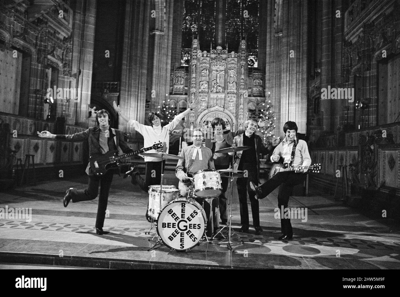 The Bee Gees perform at Liverpool Anglican Cathedral. The Bee Gees are brothers Maurice, Barry and Robin Gibb, Colin Peterson and Vince Malouney. The Dean of Liverpool, Rev. Edward Patey could not resist trying out the drums. 14th December 1967. Stock Photo