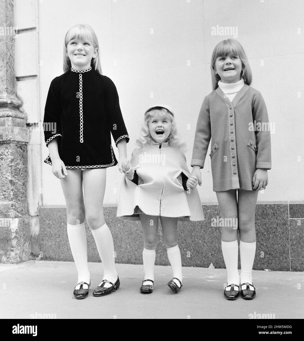 Tick a Tee Clothing manufacturer has designed a boutique range for children, shown here modelling the clothes in Conduit Street, London, Wednesday 31st July 1968.  Our Picture Shows ... child models (left to right) Shareigne Ridley (7), Samantha Gates (3) and Dhareigne Ridley (6). Stock Photo