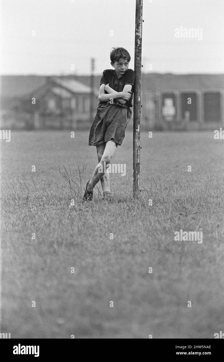 David Bradley, (aged 14) playing the part of Billy Casper, pictured with his Kestral, on the film set of the film Kes.   Here Billy Casper is playing the goalkeeper in the school football match scene.  Kes is a 1969 release drama film directed by Ken Loach and produced by Tony Garnett. The film is based on the 1968 novel A Kestrel for a Knave, written by the Barnsley-born author Barry Hines. The film is ranked seventh in the British Film Institute's Top Ten (British) Films and among the top ten in its list of the 50 films you should see by the age of 14.     The film was shot on location aroun Stock Photo