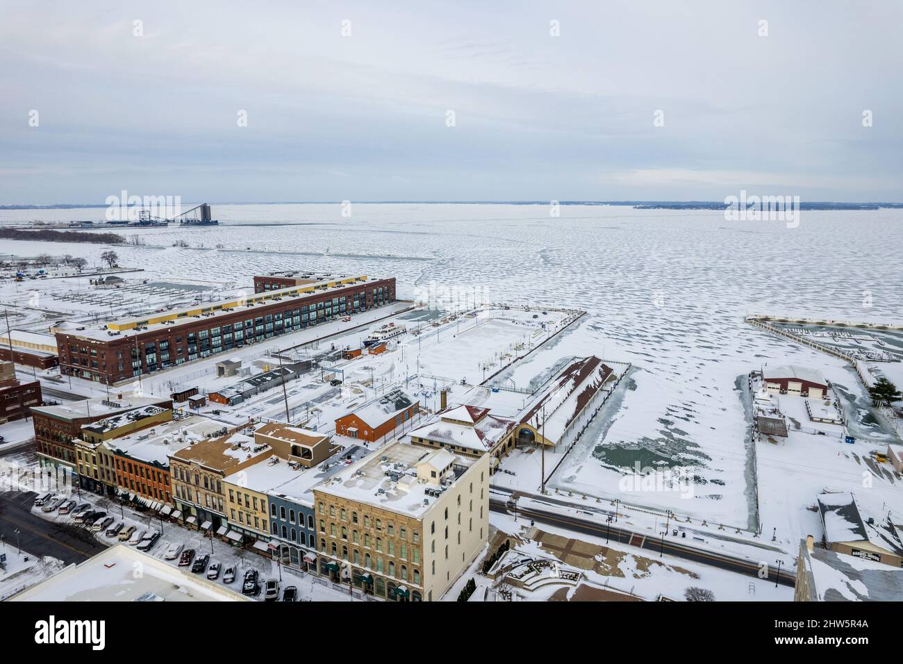 Aerial view of a city with mid-rise buildings covered in snow and a ...