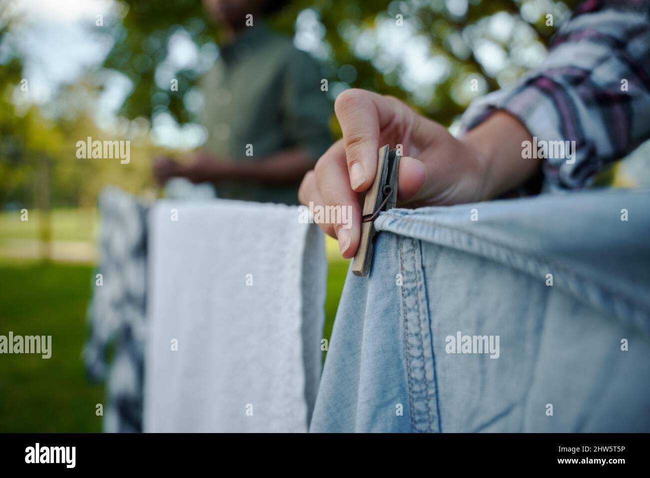 Close up male and female famers hanging out dirty washing Stock Photo