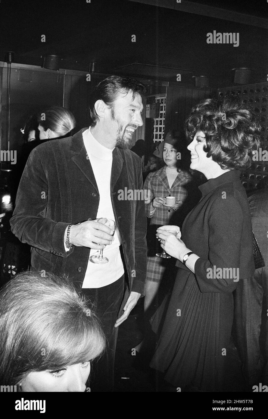 Wedding reception of Polish film director Roman Polanski and his bride, American actress Sharon Tate, held at the London Playboy Club following their wedding at Chelsea Register Office. Actress  Joan Collins talking to actor Laurence Harvey at the reception. 20th January 1968. Stock Photo