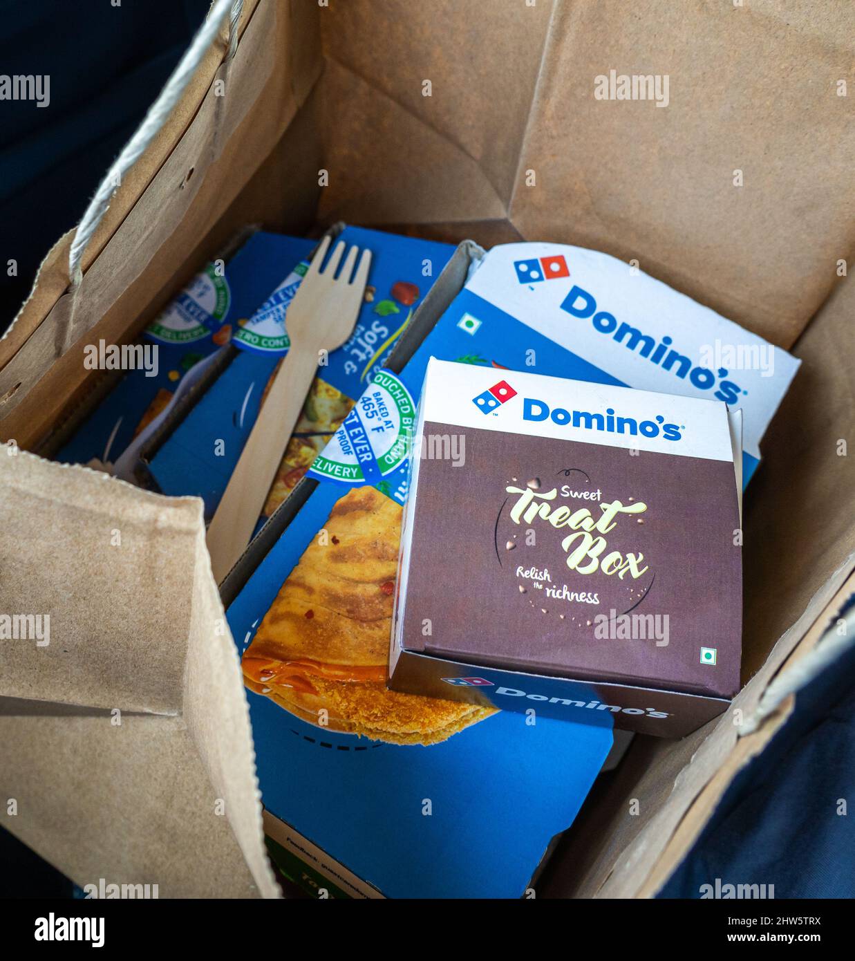 Domino's boxes placed in a paper carry bag. Takeout food order. Stock Photo