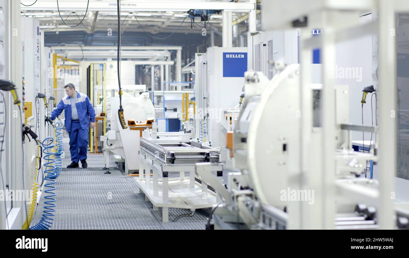 Russia, Moscow - October, 2019: Worker checks processes in modern equipped enterprise. Scene. Factory worker checks and monitors maintenance of shop w Stock Photo