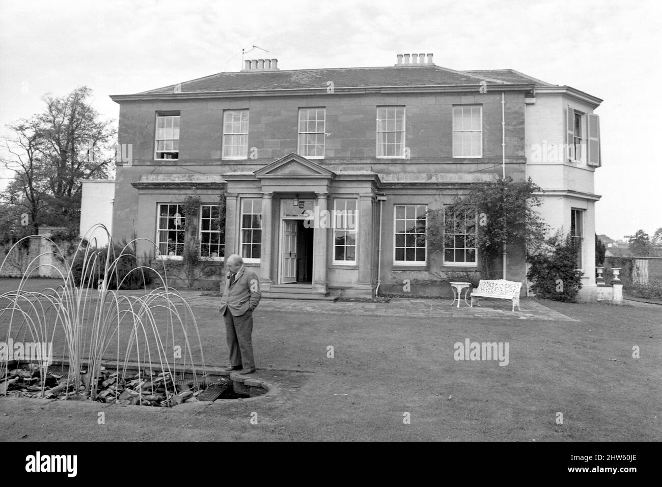 Novelist J. B. Priestley in the garden of his home, Kissing Tree House