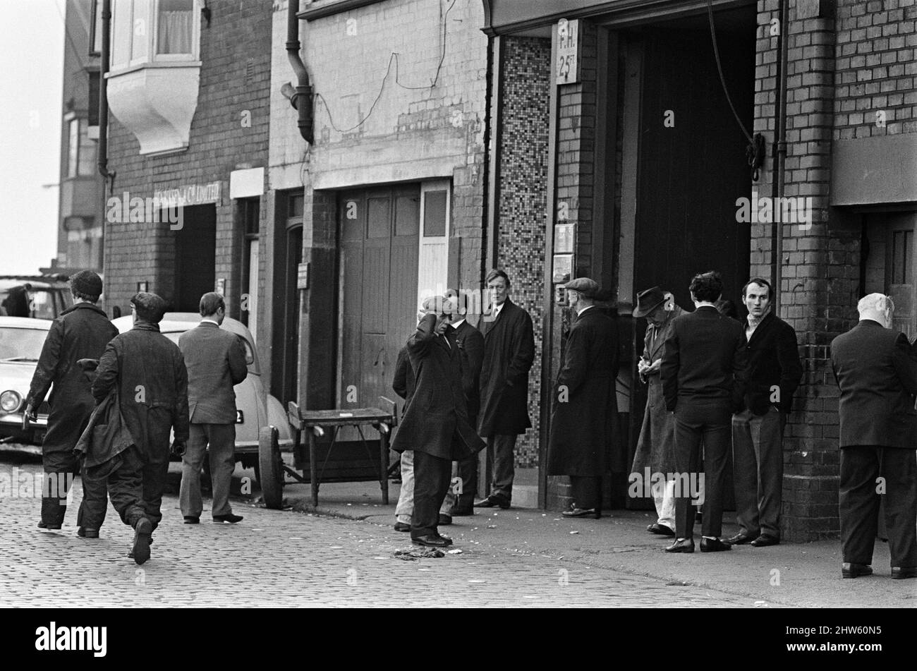 Trawlermen wait outside one of the company offices on the fish dock to