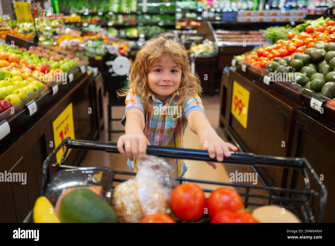 Child boy is shopping in a supermarket. Child buying fruit in