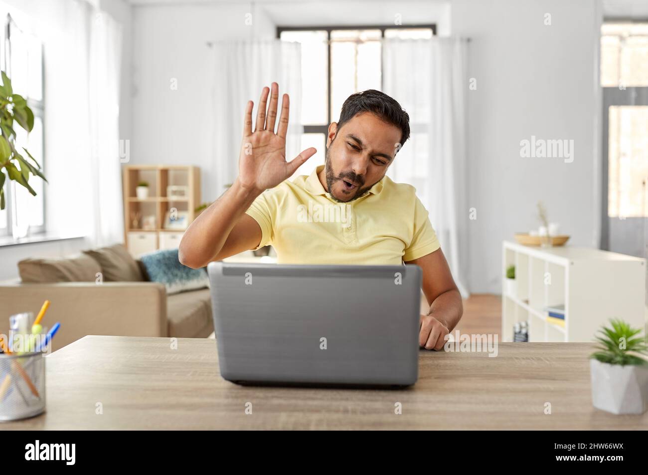 man with laptop has video chat and makes high five Stock Photo