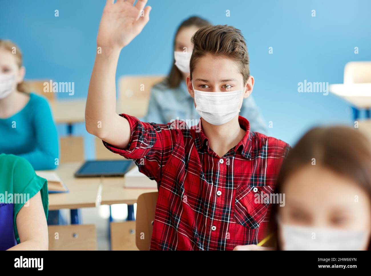 student boy in mask with raised hand at school Stock Photo Alamy