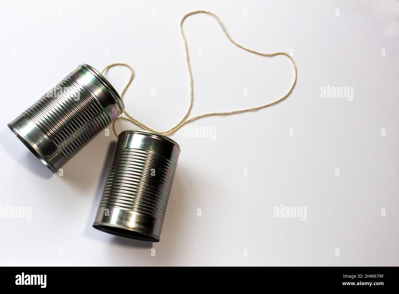 Overhead view of two tin can phones with string in a heart shape, early stages of a relationship with good communication. 1 of 4. Space for ext Stock Photo