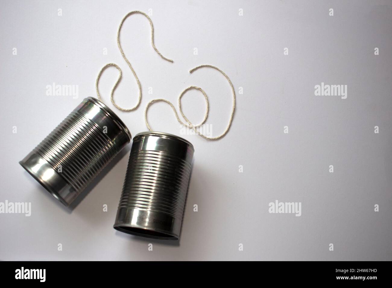 Overhead view of two tin can phones with strings cut, suggesting communication breakdown. 3 of 4. Space for text Stock Photo