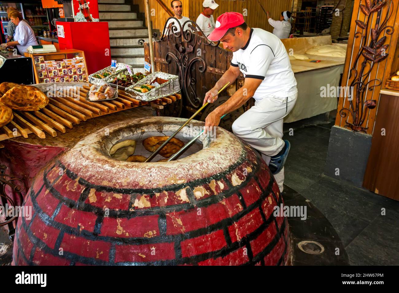 APARAN,ARMENIA - SEPTEMBER 1,2013:In the city of Aparan there is the most famous bakery 'Gnutnik' Unknown man takes bread out of the oven. Stock Photo