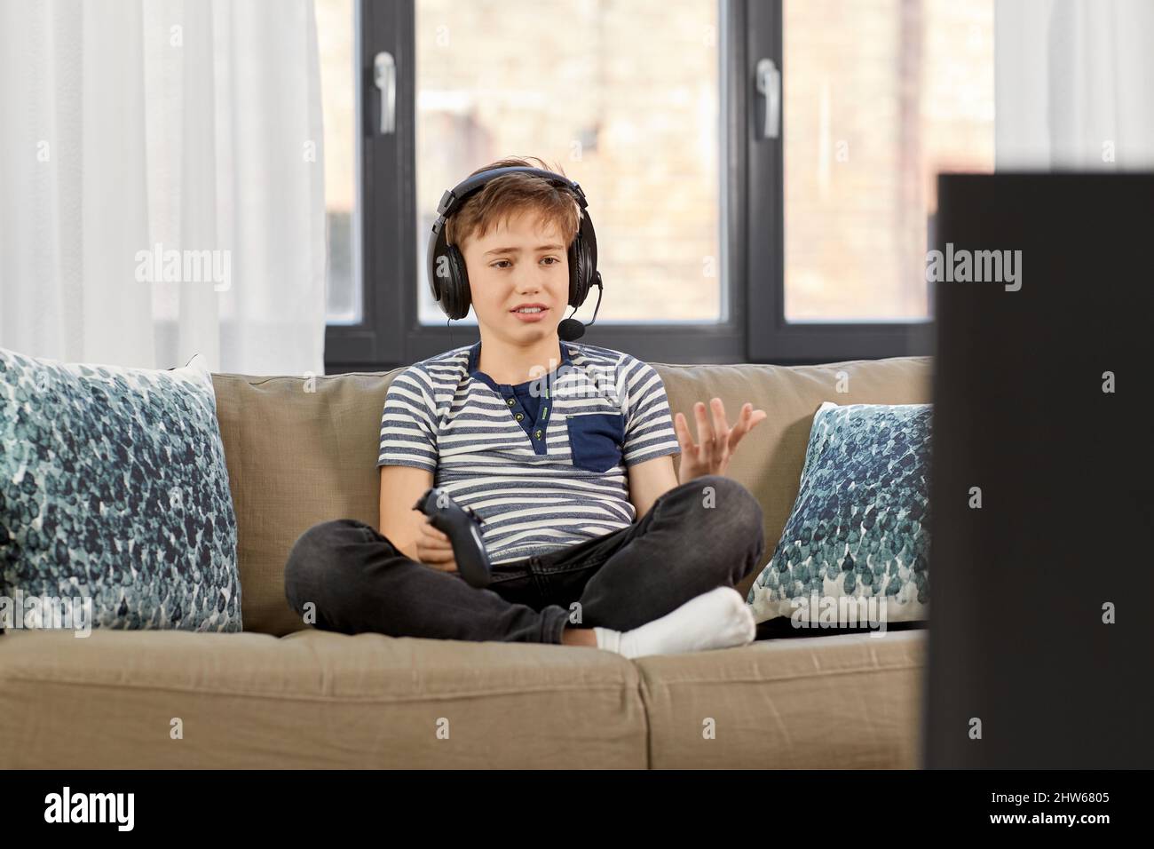 upset boy with gamepad playing video game at home Stock Photo