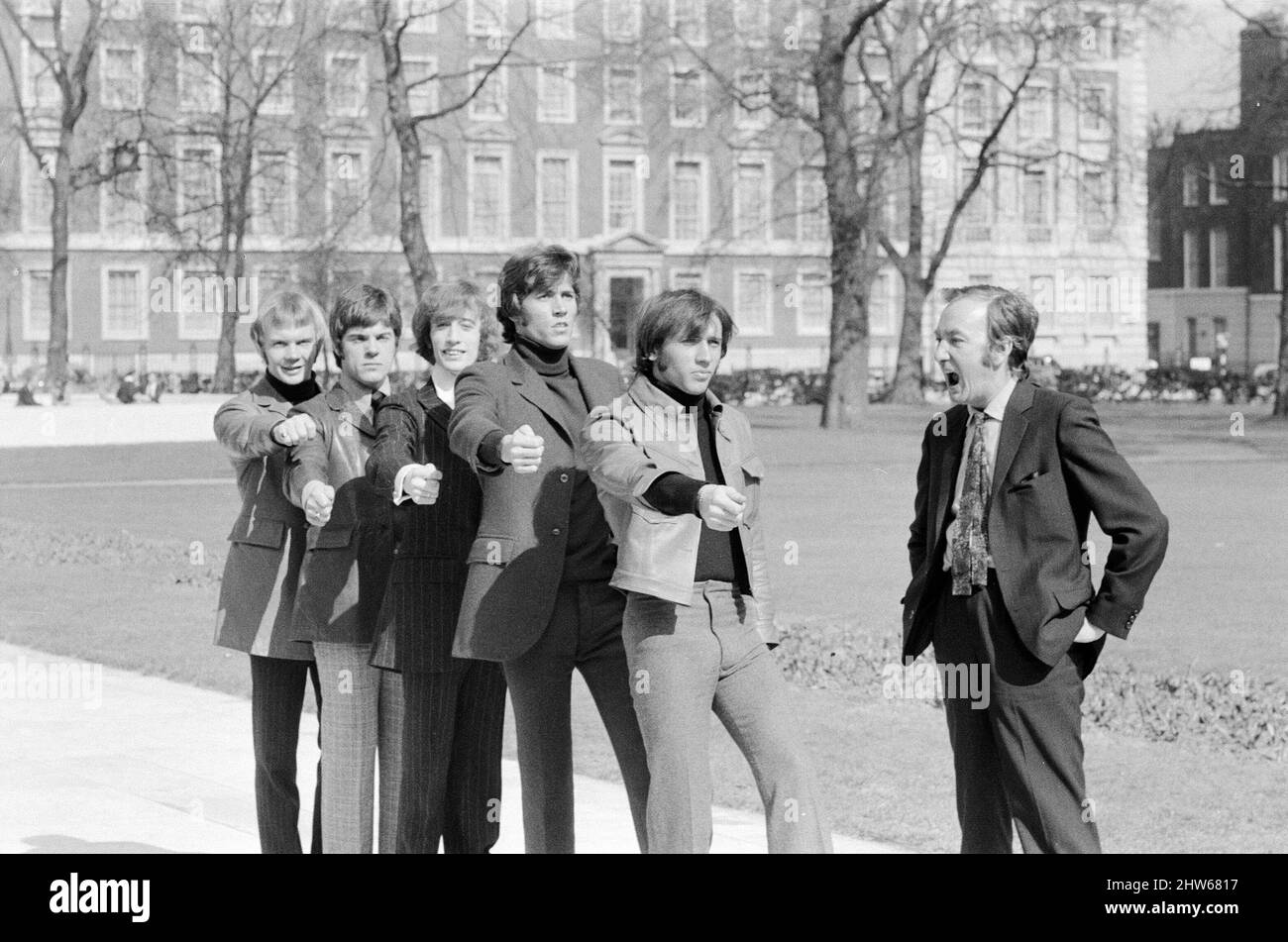 The Bee Gees are put through their paces by Britain's top comedy writer Johnny Speight, who will be writing the screenplay for their first full length feature film 'Lord Kitchener's Little Drummer Boys'. The plot concerns the press ganging of the boys to join the army as bandsmen during the Boer War, filming starts later this year.   Johnny marches The Bee Gees through London as he gives them a taste of what's to come 29th March 1968.    Pictured (l to r) Vince Melouney, Colin Peterson, Robin Gibb, Barry Gigg & Maurice Gibb with Johnny Speight Stock Photo