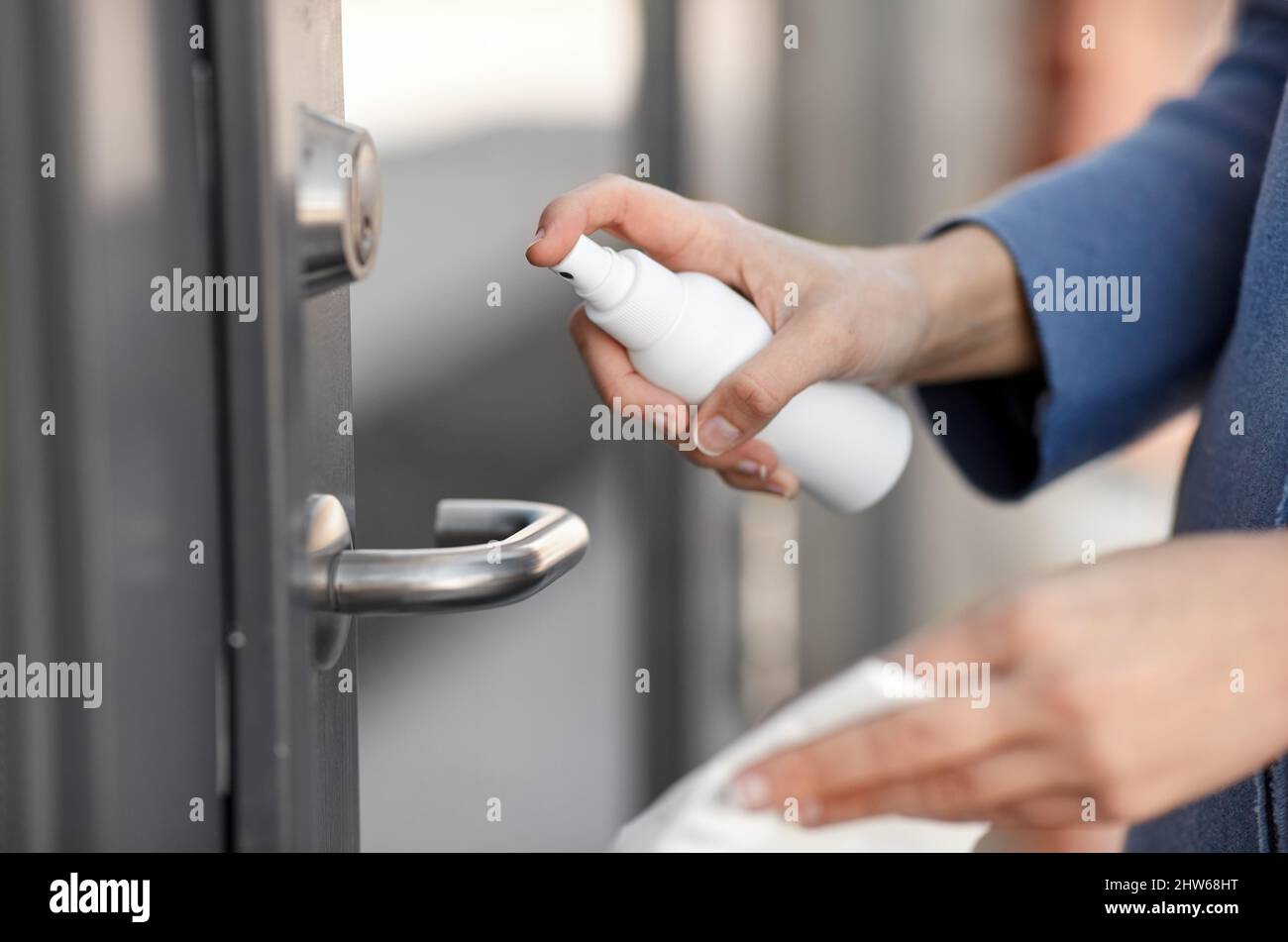 hand cleaning door handle with disinfectant spray Stock Photo Alamy