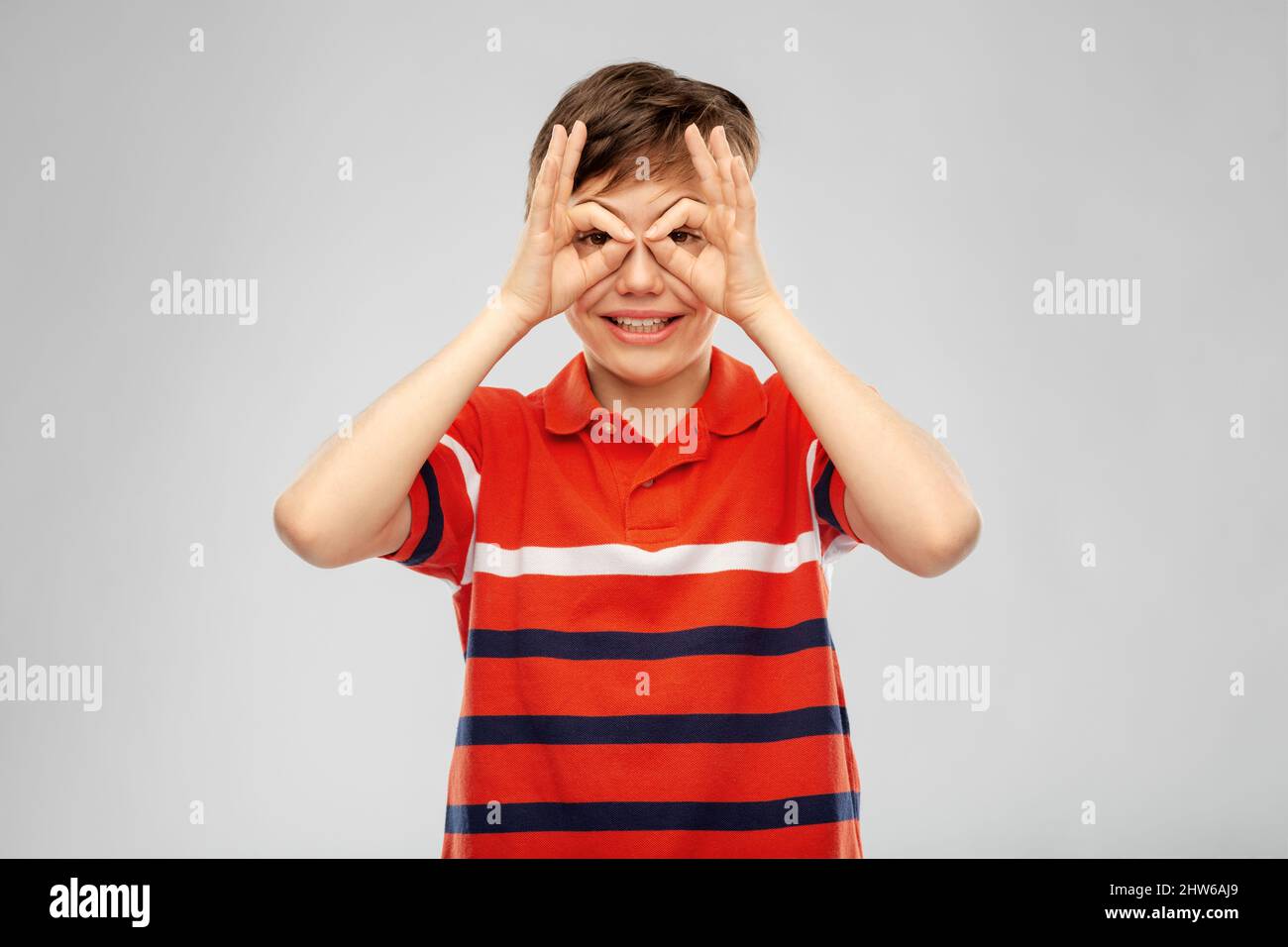 happy smiling boy looking through finger glasses Stock Photo