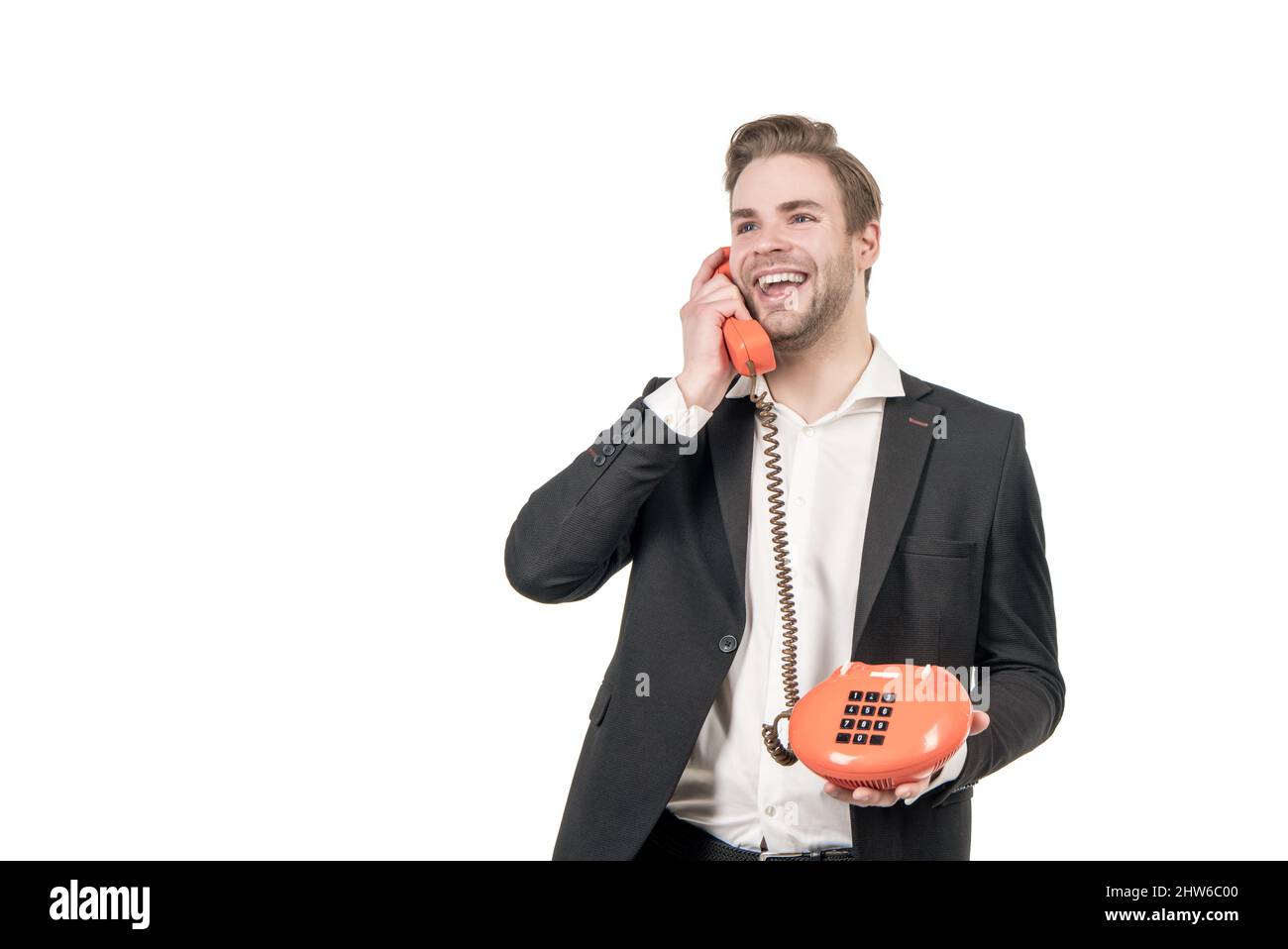 Happy guy talk in vintage telephone receiver holding retro landline phone, communication. Stock Photo