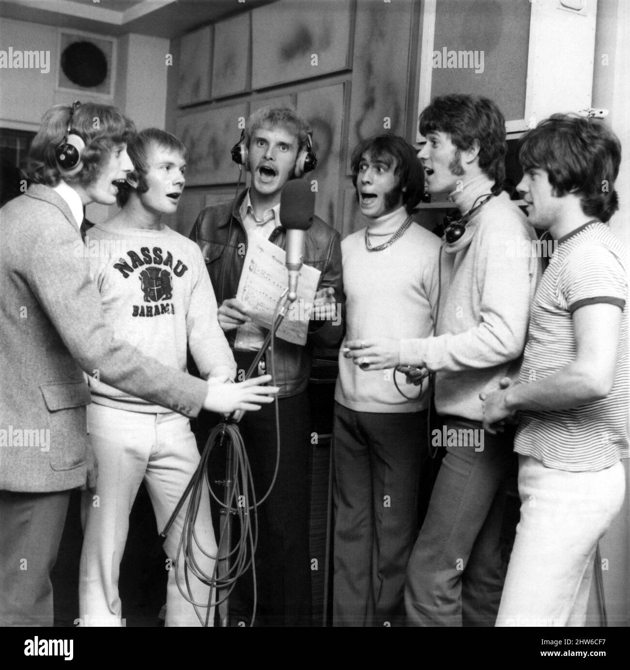 Singing along with tennis ace Ray Moore in the recording studio are Bee Gees Robin Gibb (left), Colin Petersen, Maurice Gibb, Barry Gibb and Vince Melouney.  July 1968. Stock Photo