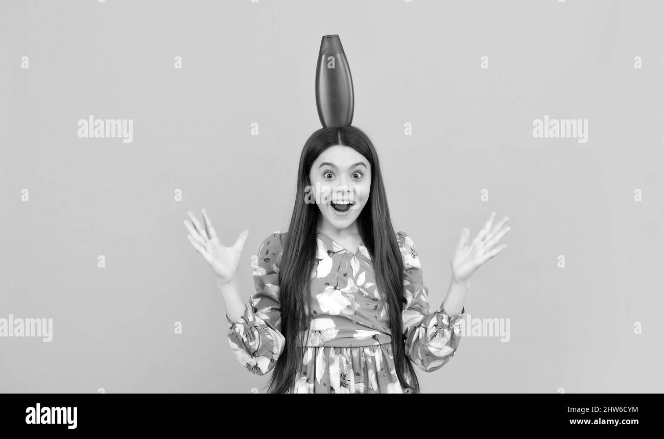 surprised kid with long hair hold shampoo bottle, hairdresser Stock