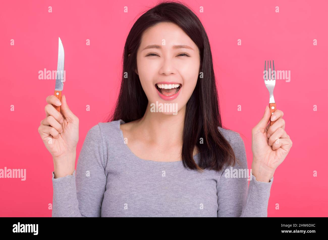 Happy Young  woman  hold fork knife and wait for tasty meal Stock Photo