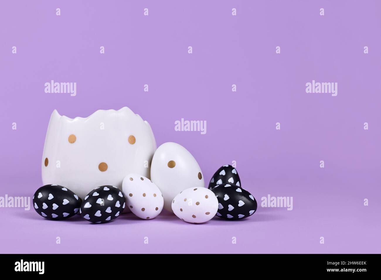 Black and white easter eggs with dots and hearts and egg cup on violet ...