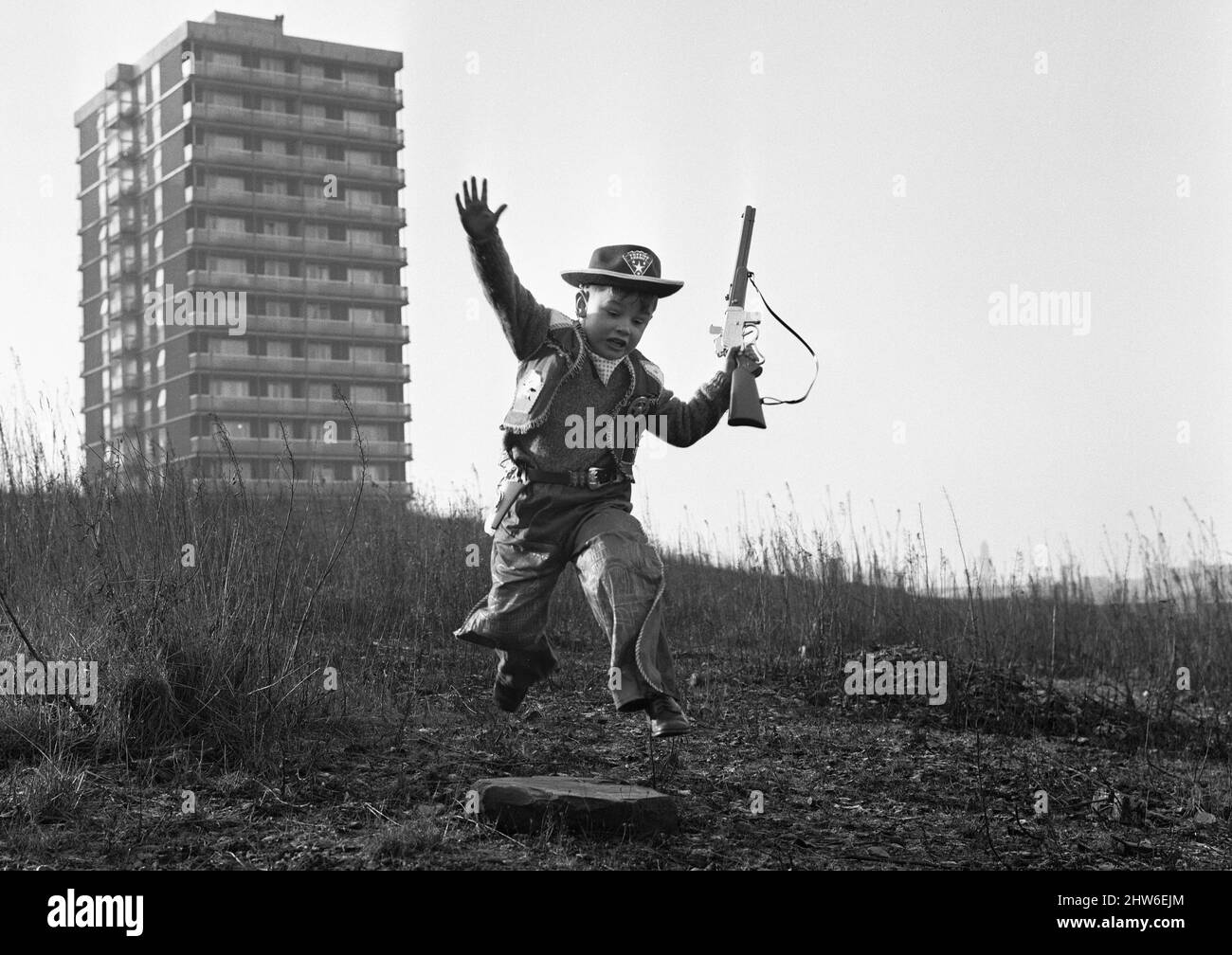 Young boy playing cowboys in Collyhurst, Manchester 14th January 1968His grandfather knew this street when tiny terraced houses stared at each other. His father remembers the bulldozers moving in. To this day it's a playground where the rubble of the past is giving way to a new frontier. Stock Photo