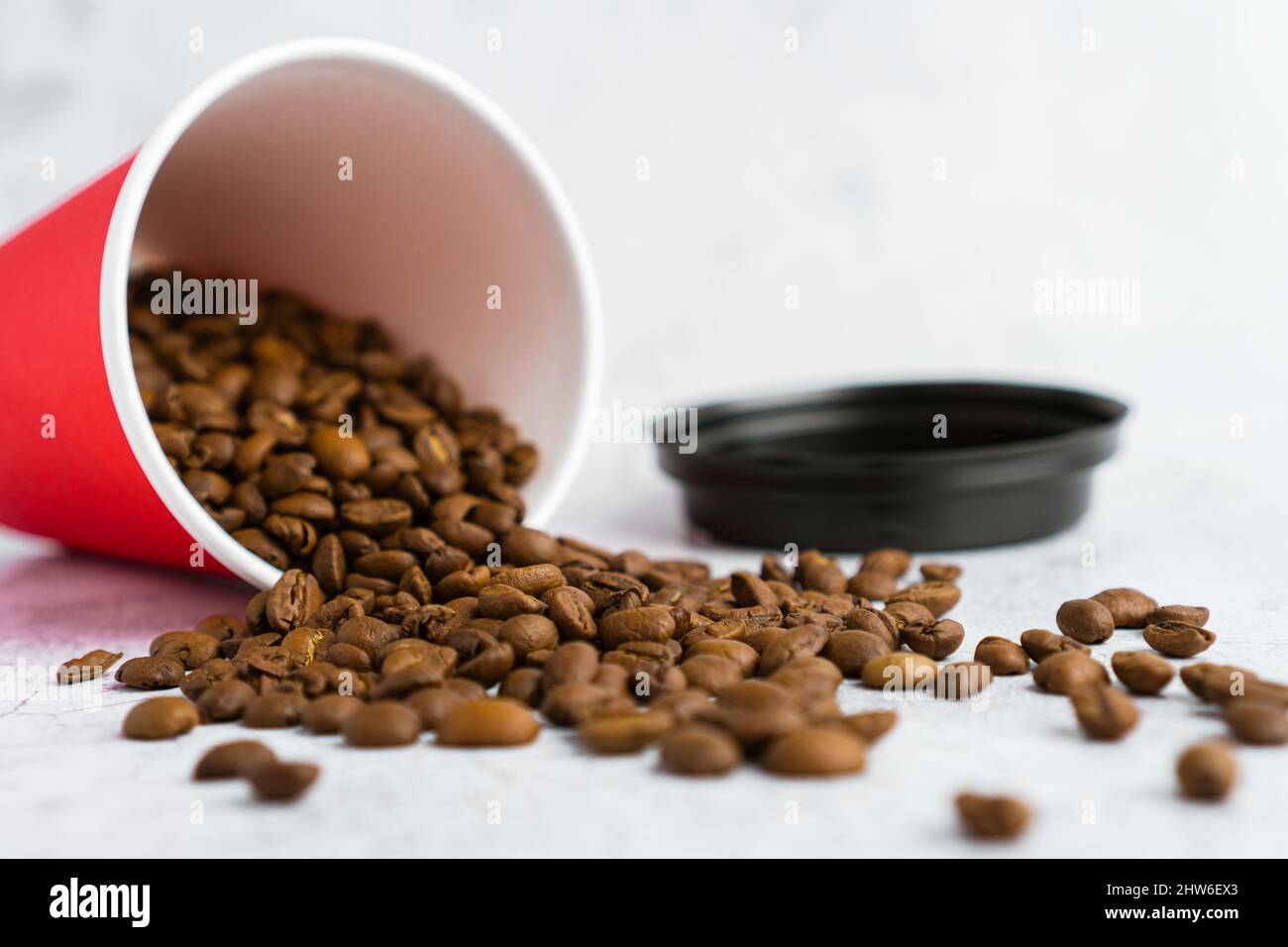 Takeaway red paper coffee cup with black cap on gray background with ...