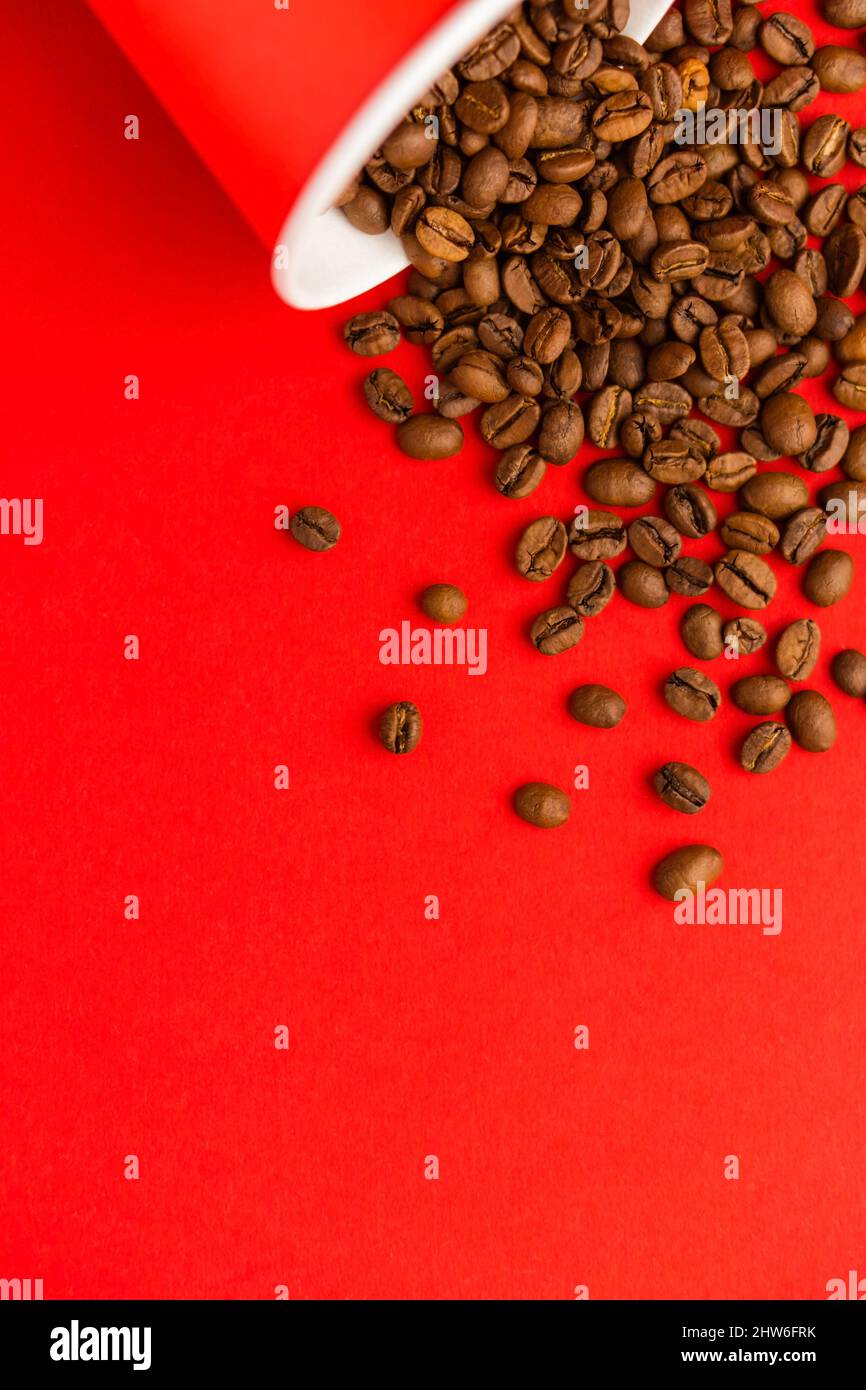 Takeaway red paper coffee cup on red background with pouring roasted ...