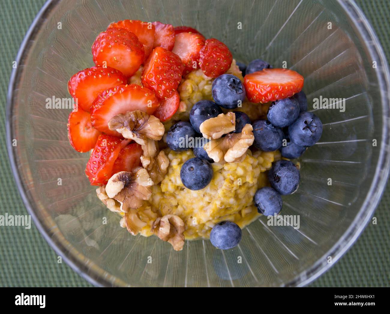 Bowl of pumpkin spice steel cut oatmeal with fresh strawberries, blueberries and walnuts. Stock Photo