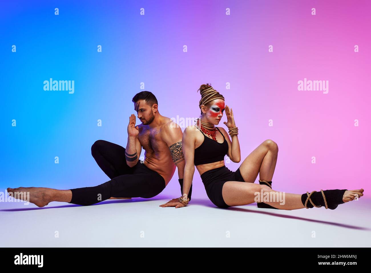 Beautiful young acrobats or gymnasts with colorful face painting on ...