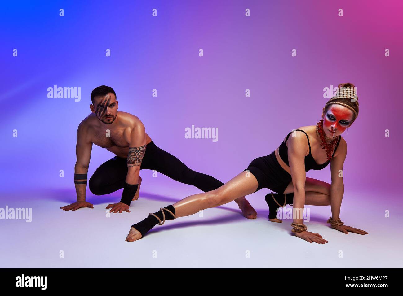 Beautiful young acrobats or gymnasts with colorful face painting on ...