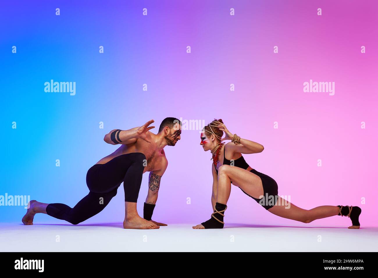 Beautiful young acrobats or gymnasts with colorful face painting on ...