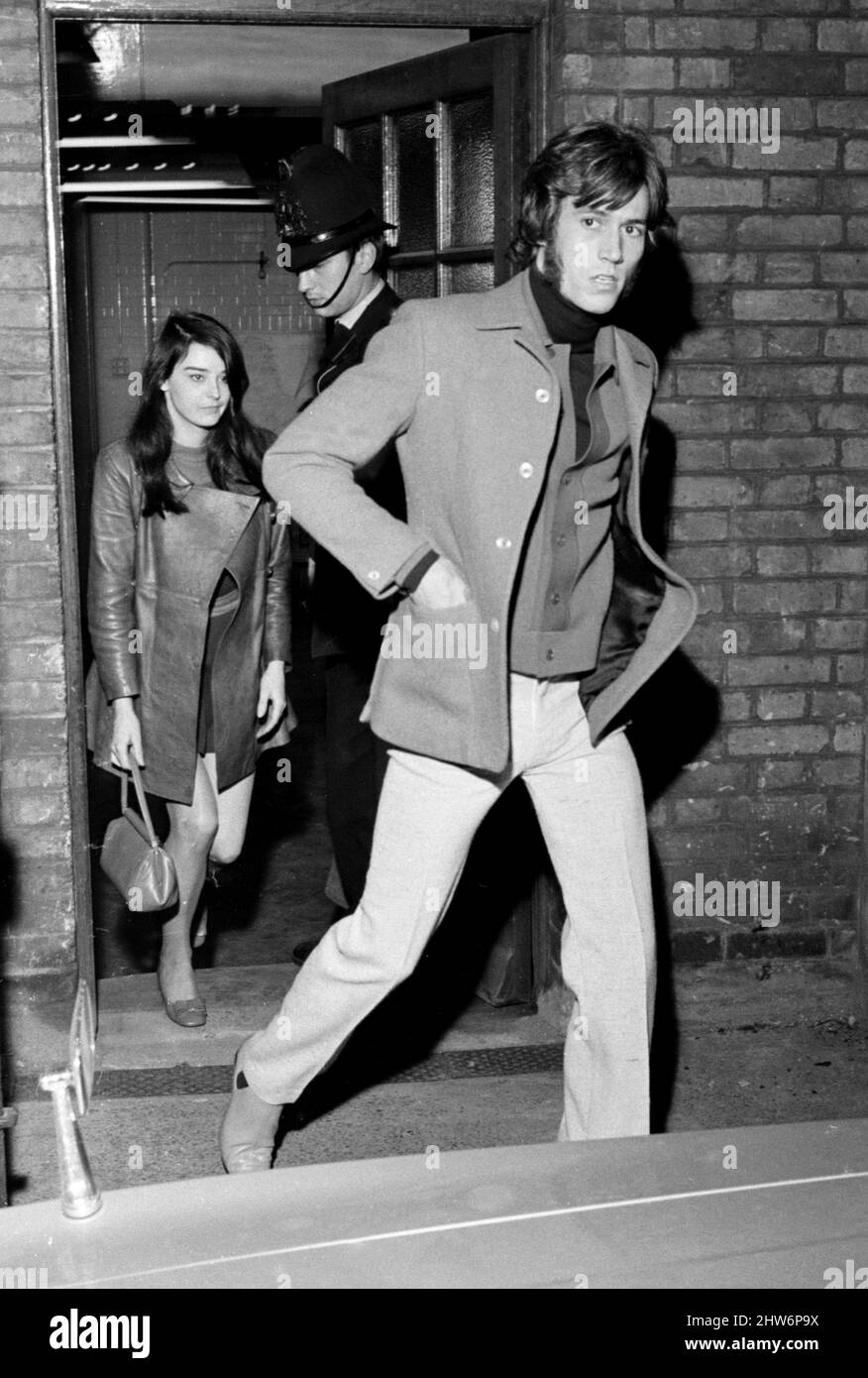Pop star Barry Gibb, lead singer of the Bee Gees pop group pictured with his girlfriend Linda Gray as they leave Snow Hill police station. He was taken there after a revolver was fired outside his penthouse flat in the City of London October 1968 Stock Photo