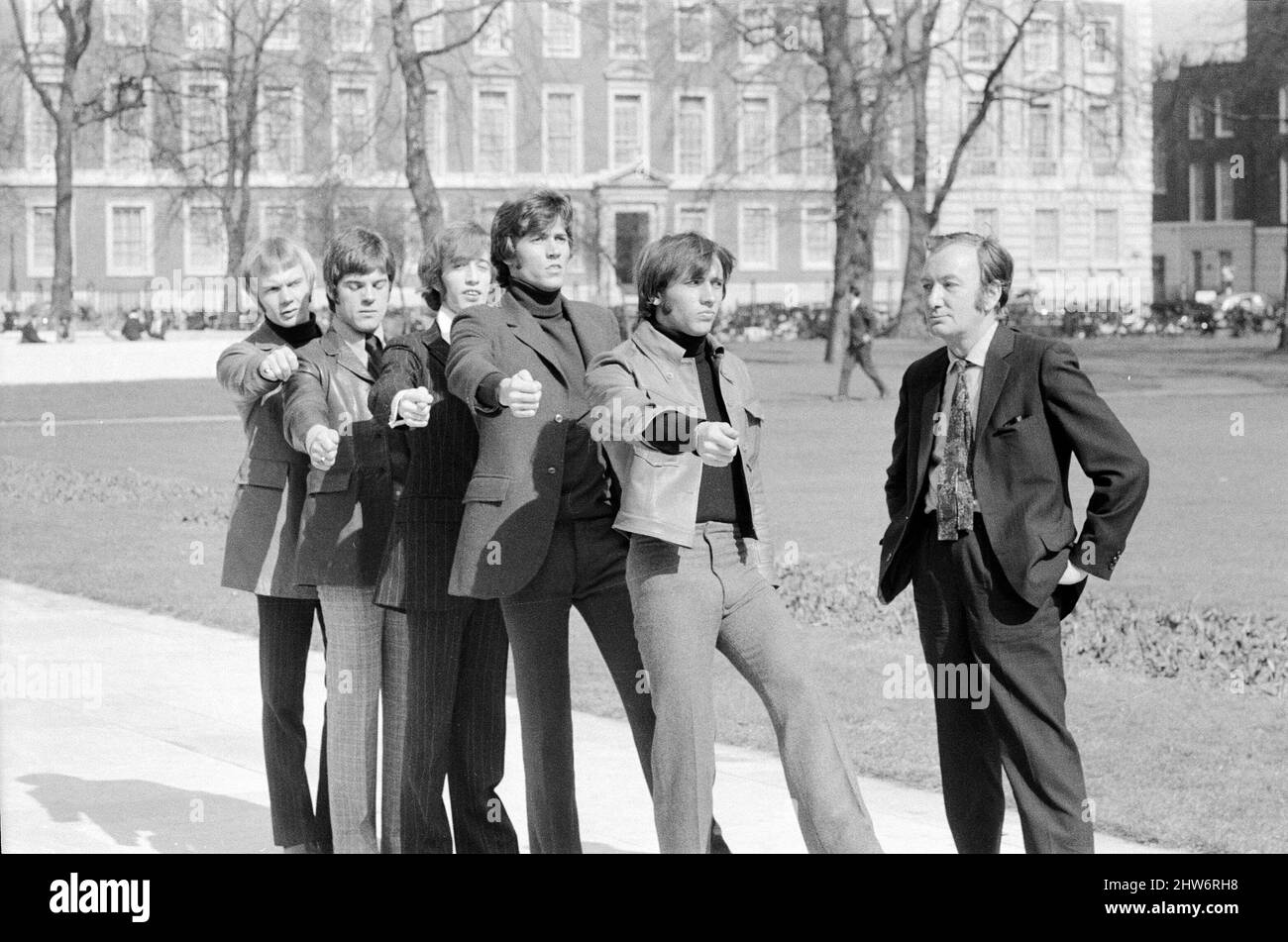 The Bee Gees are put through their paces by Britain's top comedy writer Johnny Speight, who will be writing the screenplay for their first full length feature film 'Lord Kitchener's Little Drummer Boys'. The plot concerns the press ganging of the boys to join the army as bandsmen during the Boer War, filming starts later this year.   Johnny marches The Bee Gees through London as he gives them a taste of what's to come 29th March 1968.    Pictured (l to r) Vince Melouney, Colin Peterson, Robin Gibb, Barry Gigg & Maurice Gibb with Johnny Speight Stock Photo