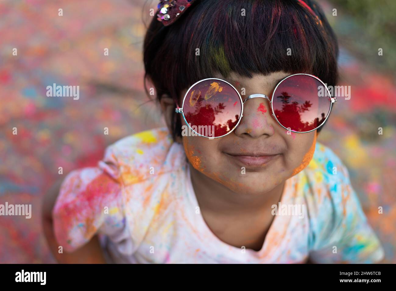 Indian Festive Theme - Happy Asian Kid Baby Girl Having Fun With Non Toxic Herbal Holi Color Powder Called Gulal Or Abir Rang Abeer Stock Photo