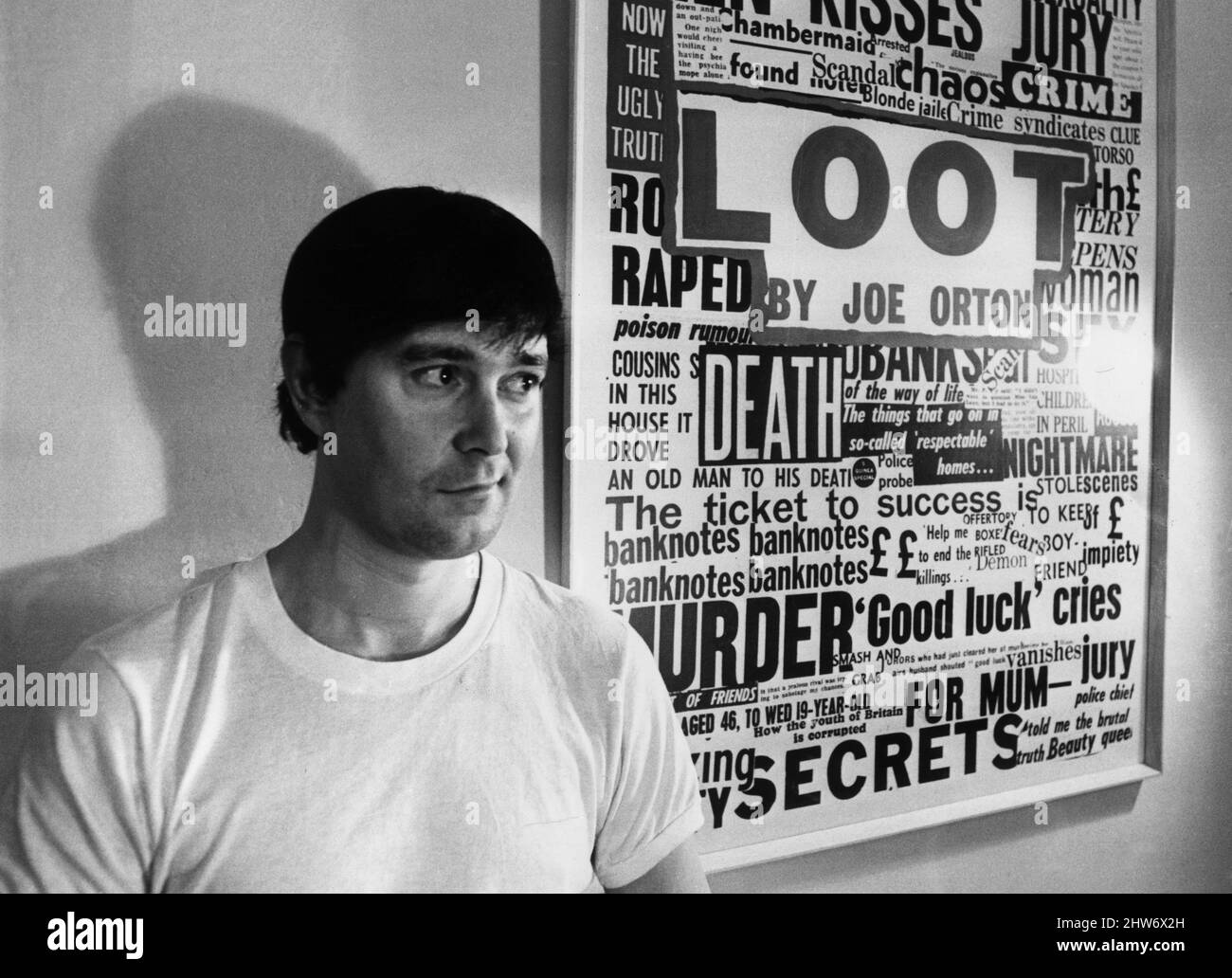 Playwright Joe Orton next to a promotional poster of his new play 'Loot'. 1967. Stock Photo