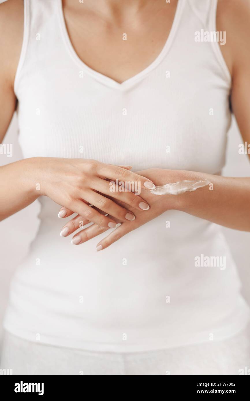 Closeup of female hands applying hand cream.Hand Skin Care. Girl hands with french manicure. Stock Photo