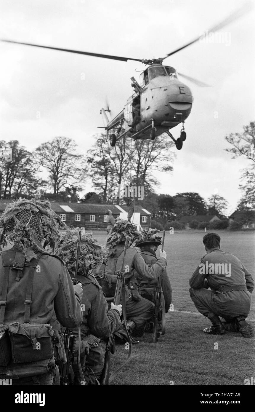 During a visit by Prince Philip, Duke of Edinburgh (not in picture), to the Infantry Junior Leaders Battalion at Park Hall Camp, Oswestry, Shropshire. In camouflaged battledress and camp's boy soldiers do an airborne cavalry exercise on the cricket field. In squads of six they run to RAF Whirlwind helicopters and are whisked off. A quick flight round the camp and the helicopters are once again over the cricket field. The boys, all aged between 15 and 17 disembark by ropes as the machines over 20ft above the ground. 26th May 1967. Stock Photo