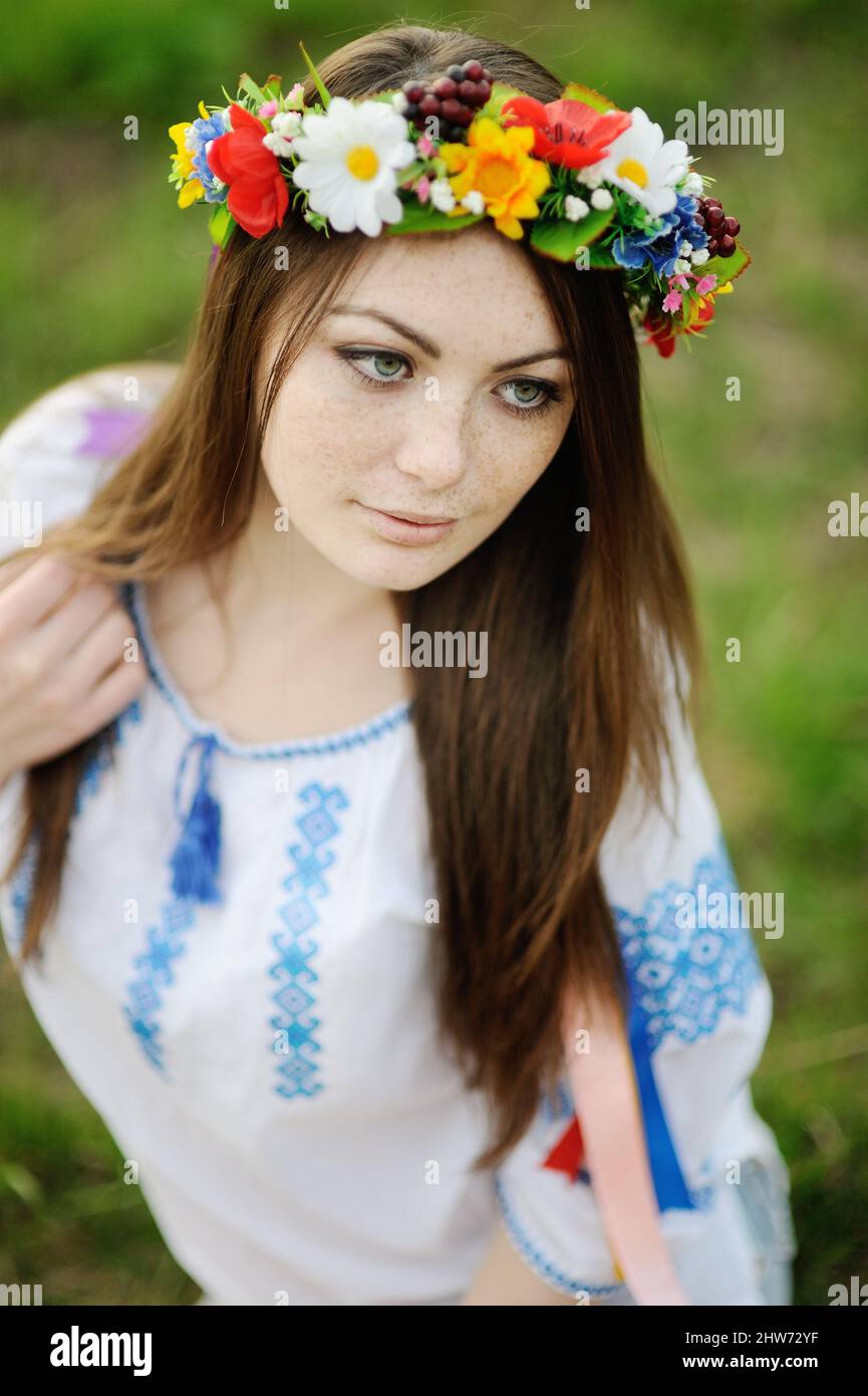 girl with freckles on her face in a Ukrainian shirt and floral bouquet ...