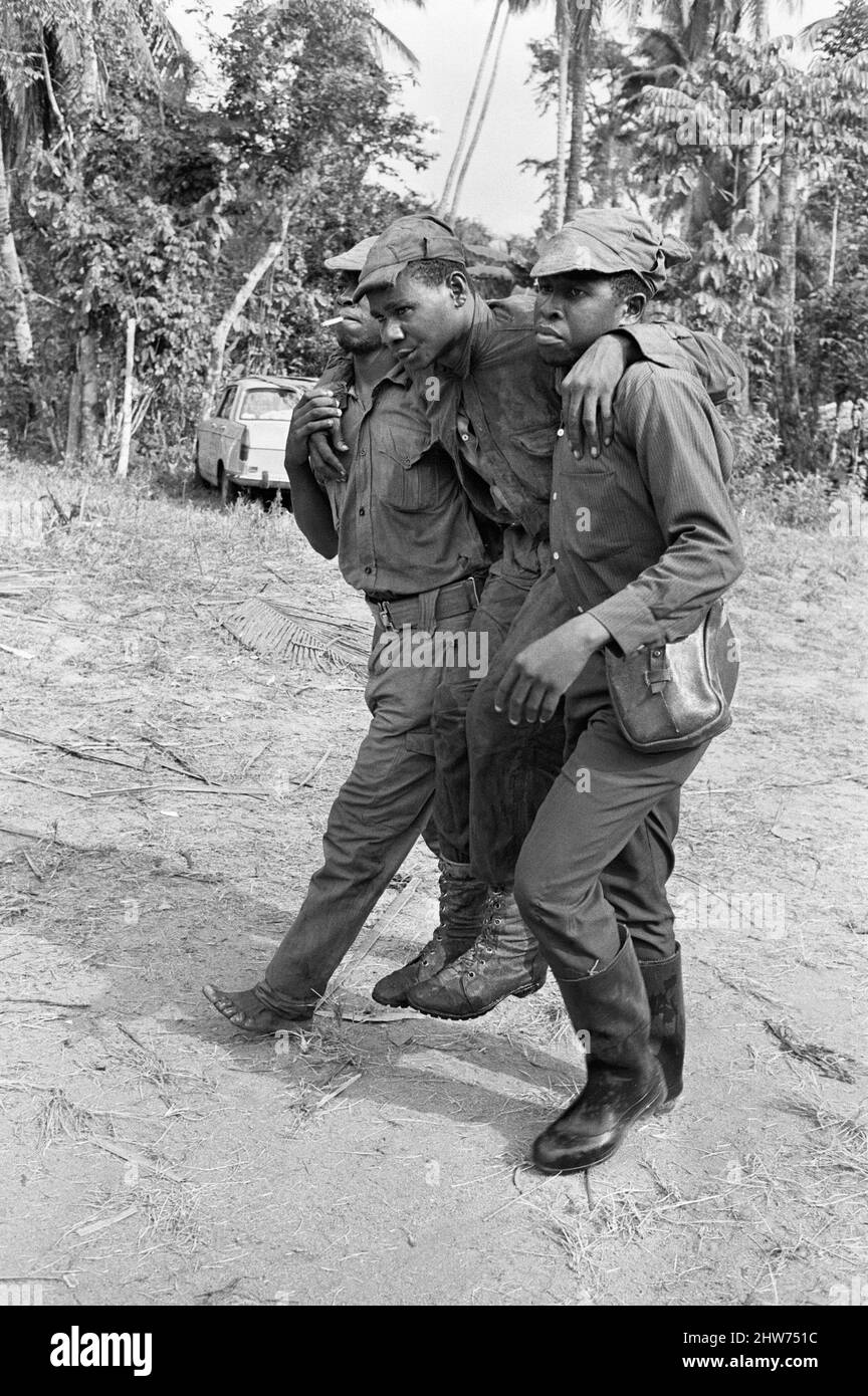 Biafran soldiers seen here carrying an injured comrade during the Biafra conflict. 11th June 1968.  The Nigerian Civil War, also known as the Biafran War endured for two and a half years, from  6 July 1967 to 15 January 1970, and was fought to counter the secession of Biafra from Nigeria. The indigenous Igbo people of Biafra felt they could no longer co-exist with the Northern-dominated federal government following independence from Great Britain. Political, economic, ethnic, cultural and religious tensions finally boiled over into civil war following the 1966 military coup, then  counter-coup Stock Photo