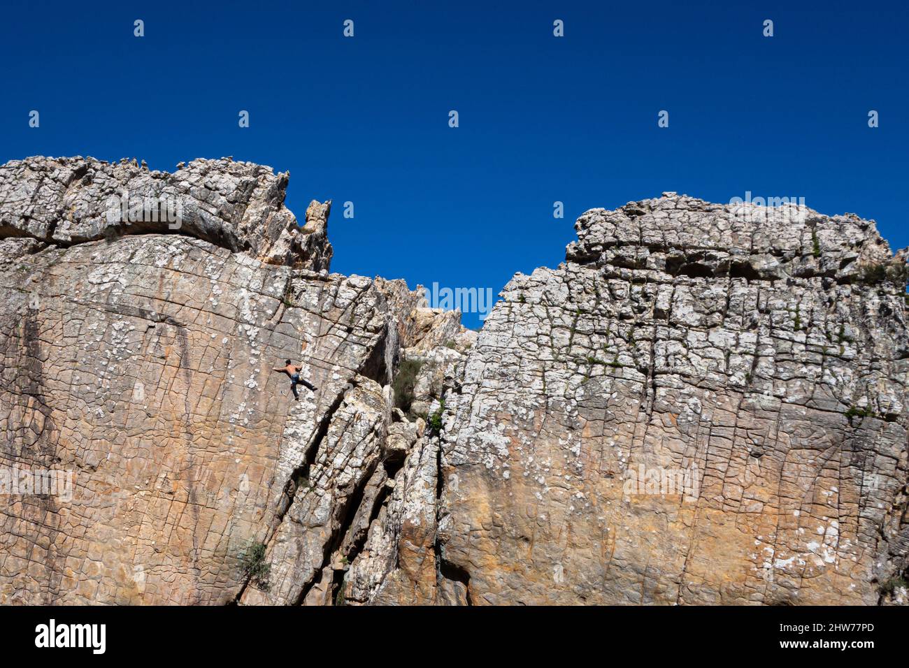 Single male person solo climber climbing a vertical pitch route in Zona de Escalada Tajo del Buho in Betis, near Tarifa in Spain Stock Photo