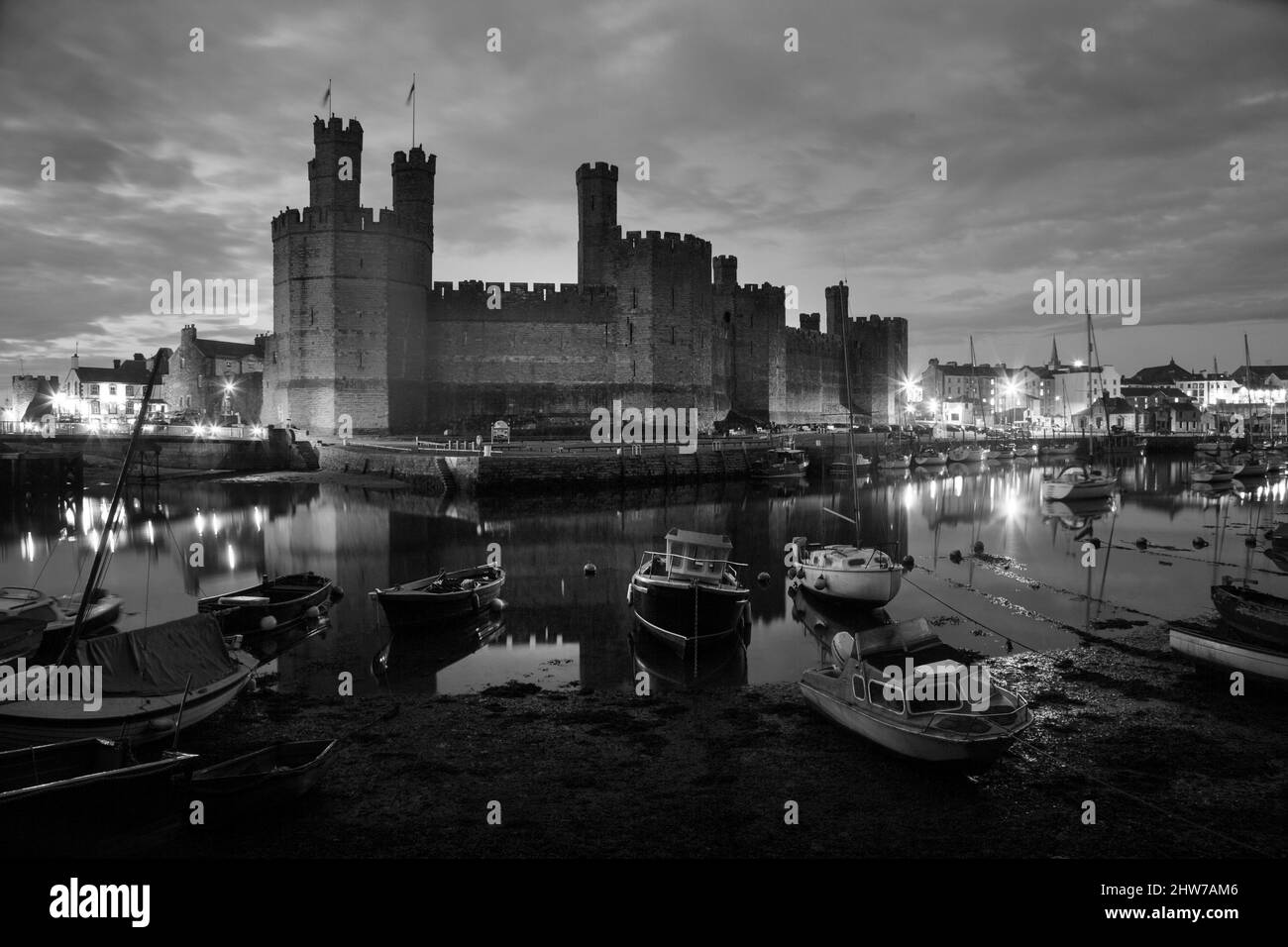 Black & White landscape medieval fortress Caernarfon Castle Gwynedd Wales UK copy space boats on river Seiont Stock Photo