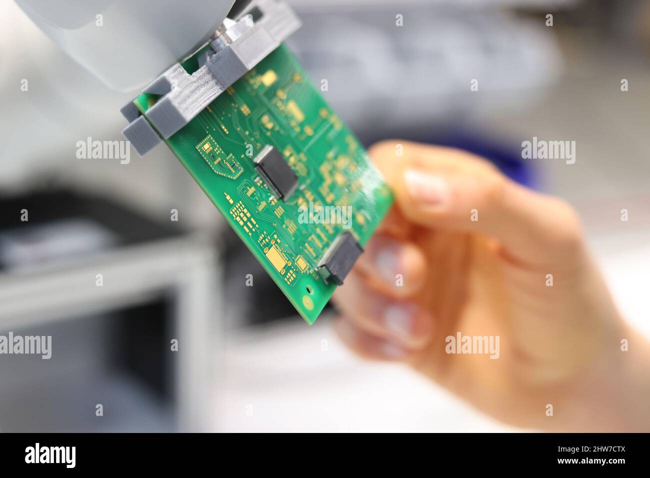 04 March 2022, Bavaria, Würzburg: A scientific employee checks a circuit  board used in a small satellite at the Center for Telematics. During a visit  by Melanie Huml, Minister for Europe (CSU),