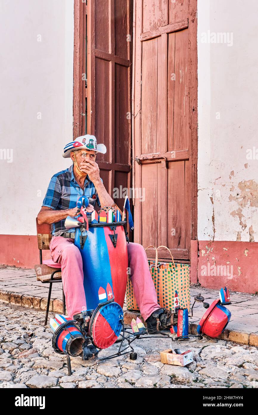 Local senior man playing handmade drum kit, harmonica on street of old colonial town Trinidad, Cuba Stock Photo
