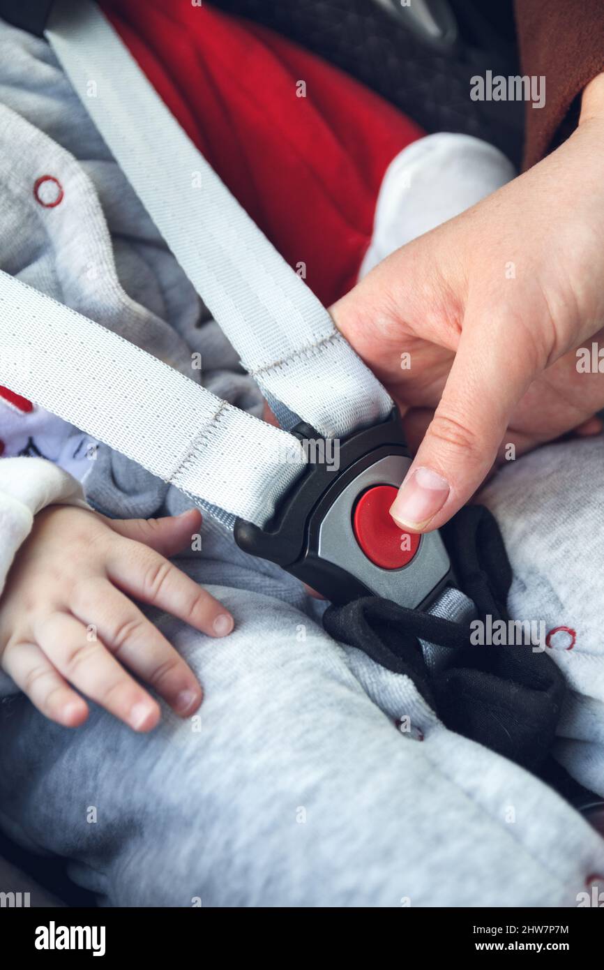 Infant sitting in baby car seat with safety belt locked protection Stock Photo