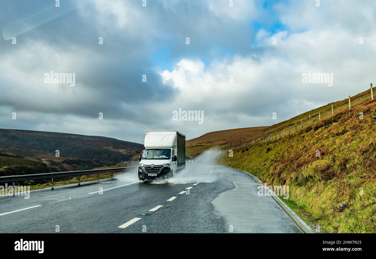 A van climbs up through a wet flooded Woodhead pass, connecting Greater Manchester with South Yorkshire. The A628 is a mayor link road that is prone t Stock Photo